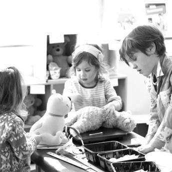 Black and White Photo of Kids Operating on Stuffed Animals