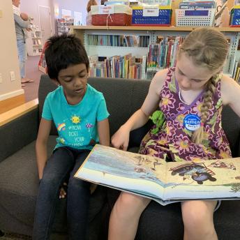 Two children reading in the library