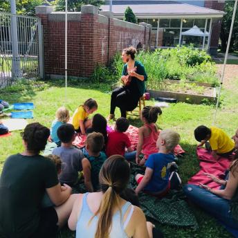 Librarian giving story time in the library garden