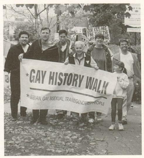 Activists carry sign saying Gay History Walk